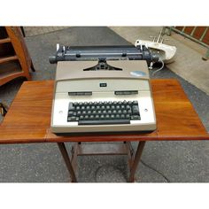 an old fashioned typewriter sitting on top of a wooden table