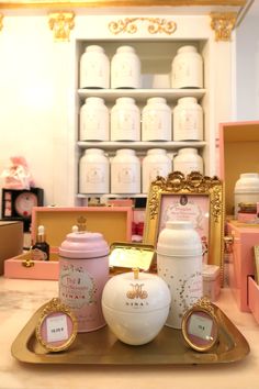 there are many items on the table in this room that is decorated with gold, pink and white