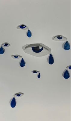 several blue and white objects floating in the air with drops of water on top of them