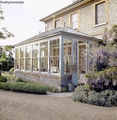 an image of a house that is in the middle of some bushes and flowers around it