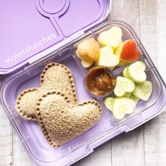 a bento box filled with lots of different types of food and some kind of heart shaped sandwich