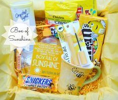 a basket filled with snacks and drinks on top of a yellow wrapper next to a cup