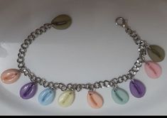 This is handmade cowrie shell bracelet with interlock system.  It's shells colours are pink, yellow, violet, orange, sky blue and olive green colour. It is made after placing order. This is adjustable item with length 20.5 cm. This item is made from colourful plastic cowrie shells in silver chain with interlock system. It is light in weight. Cowrie Shell Bracelet, Cowrie Shell Jewelry, Yellow Violet, Cowrie Shells, Orange Sky, Shell Bracelet, Olive Green Color, Shell Jewelry, Cowrie Shell