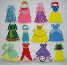 there are many different princess dresses on the white tablecloth, and one is made out of felt