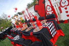 the table is set up with black and red cloths, silverware, and plates