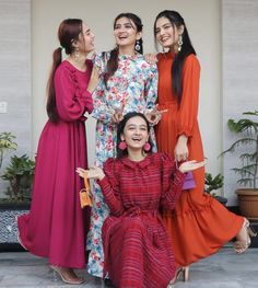 three women in colorful dresses standing next to each other