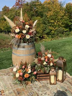 a wooden barrel filled with lots of flowers next to a lantern on top of a rug