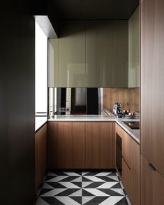 a kitchen with black and white flooring next to a counter top on the wall