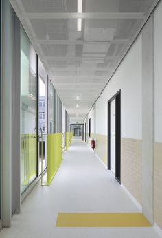 an empty hallway with yellow dividers and white walls on both sides, leading to the second floor