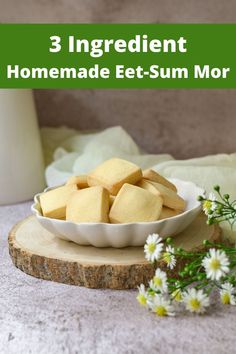 a bowl filled with cut up cookies on top of a wooden board next to flowers