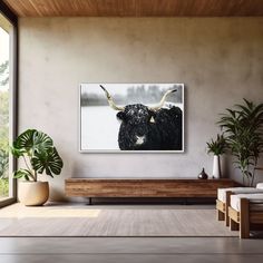 a living room scene with a cow on the wall and potted plants in the corner