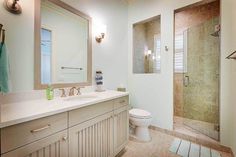 a bathroom with two sinks, a toilet and a walk - in shower next to each other