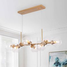 a modern chandelier with clear glass balls hanging from it's brass frame