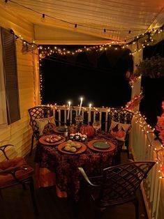 an outdoor dining area is lit up with candles