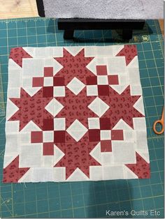 a red and white quilt on a cutting board