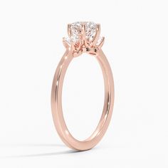 a rose gold ring with three stones on the side