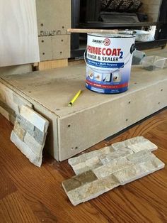 a can of paint sitting on top of a piece of cardboard next to a tv