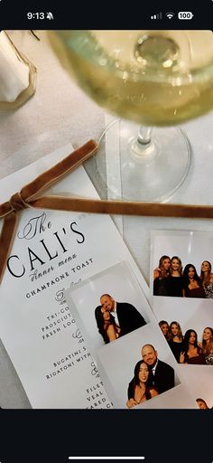 the call's wedding program is next to a glass of wine and two photos