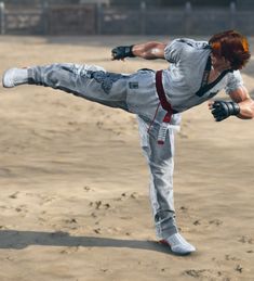 a man doing a kickbox pose in the middle of a sandy area with his legs spread out