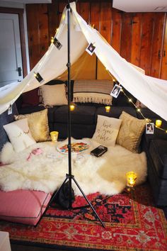 a living room with a couch, rug and lights on the wall above it is decorated in white