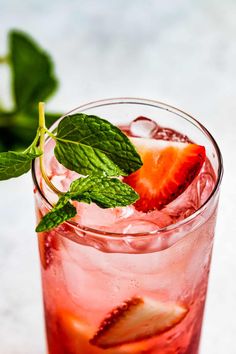 a close up of a drink with strawberries and mint