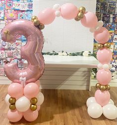 the number three balloon arch is decorated with pink, white and gold balloons