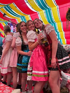 three women are posing for the camera with beer in their hands while wearing diros