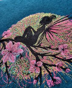 a woman sitting on top of a tree with pink flowers in her hair and the image is made out of sequins