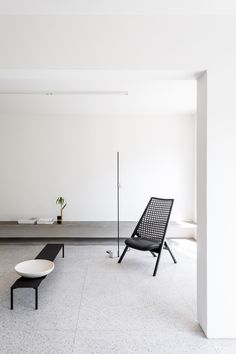 two black chairs and a white table in a room with no one on the floor