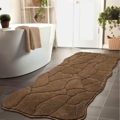 a bathroom with a bathtub and rug on the floor in front of it's door