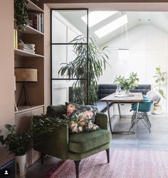 a living room filled with furniture and plants