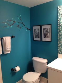 a bathroom with blue walls and pictures on the wall next to it is featured in an article titled 9 bathroom tips low cost decorating ideas