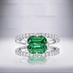 an emerald and diamond ring with two bands on each band, set in white gold