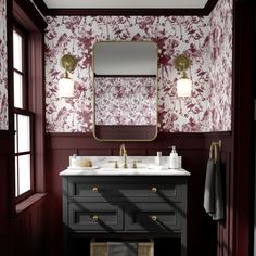 a bathroom with red and white wallpaper, two sinks and a gold framed mirror