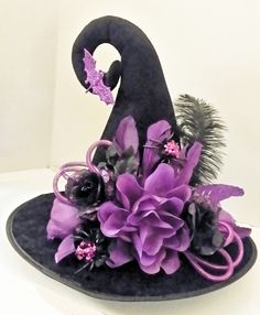 a witches hat with purple flowers and feathers