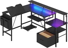 a computer desk with a blue and purple light on it's top, next to a file cabinet