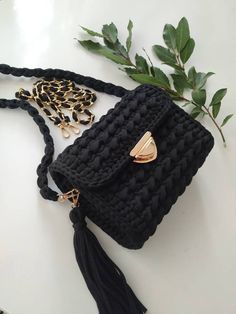 a black crocheted purse with a gold chain