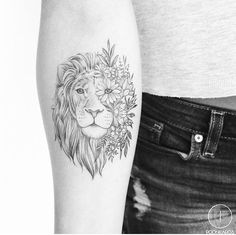 a woman's arm with a lion and flowers tattoo on the left inner forearm