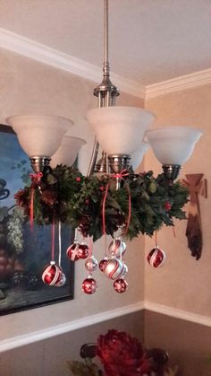 a chandelier with christmas decorations hanging from it