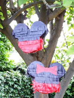 two mickey mouse pinatas hanging from a tree