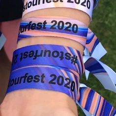 two wristbands with the names of different countries on them and ribbons in front of them