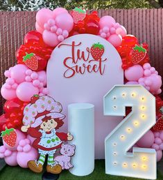 a strawberry themed birthday party with balloons and decorations