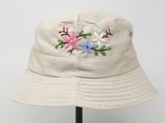 Item: flower embroidered bucket hat Material: 35% cotton, 65% polyester Size: one size fits most, brim measuring 2 inches long Embroidery: hand made with acrylic thread Free first class shipping, upgradable priority mail service. 30 days return policy, feel confident at your purchase! Adjustable Cream Cotton Bucket Hat, Cream Brimmed Cotton Bucket Hat, Outdoor Cream Cotton Bucket Hat, Cream Cotton Bucket Hat, One Size Fits Most, Cream Cotton Bucket Hat, One Size, Cream Cotton Bucket Hat, Summer Embroidered Beige Hat, Beige Summer Hats With Embroidered Logo, Embroidered Brimmed Bucket Hat For Summer