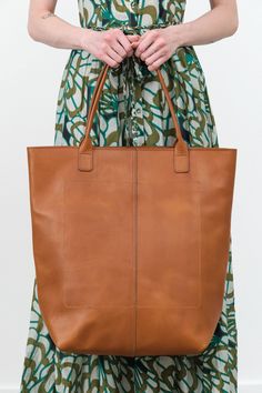 This large, durable leather tote is perfect for bringing along on trips to the farmers market, beach, or picnics. Crafted with high-quality 1.8mm vegetable-tanned Italian leather that is water-resistant and features a zippered shoulder bag design with a front-panel seam, key-hook, and spacious interior pocket. Vegetable Tanned Leather Shopping Bag With Leather Handles, Vegetable Tanned Leather Bags With Leather Handles For Shopping, Travel Tote Bag With Vegetable-tanned Leather, Rectangular Weekender Bag With Waxed Finish For Everyday Use, Cognac Vegetable-tanned Tote Shoulder Bag, Vegetable-tanned Cognac Tote Shoulder Bag, Vegetable-tanned Leather Tote Shoulder Bag, Vegetable Tanned Leather Travel Tote Shoulder Bag, Vegetable Tanned Leather Tote Shoulder Bag For Travel