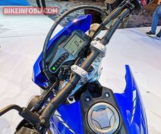 a close up of the handlebars on a blue motorcycle at an auto show