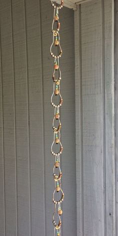 a metal chain hanging from the side of a building with lights on it's sides