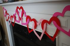 some paper hearts are hanging on the mantle