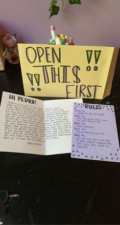 an open book sitting on top of a table next to a sign that says open whines first