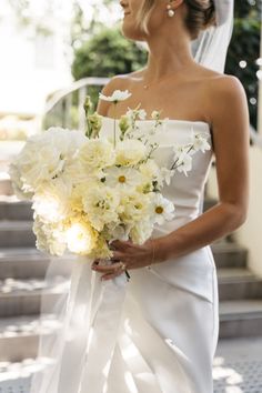 a woman in a wedding dress holding a bouquet