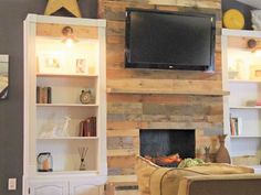 a living room with a fireplace and tv mounted on the wall above it's entertainment center